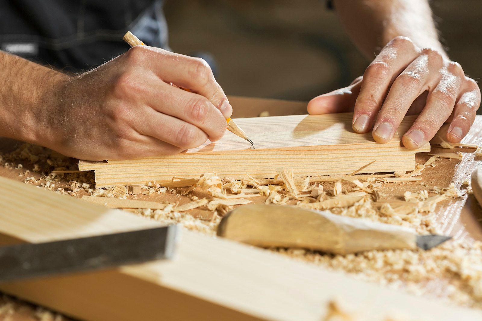 Menuisier traçant une ligne au crayon sur une planche de bois