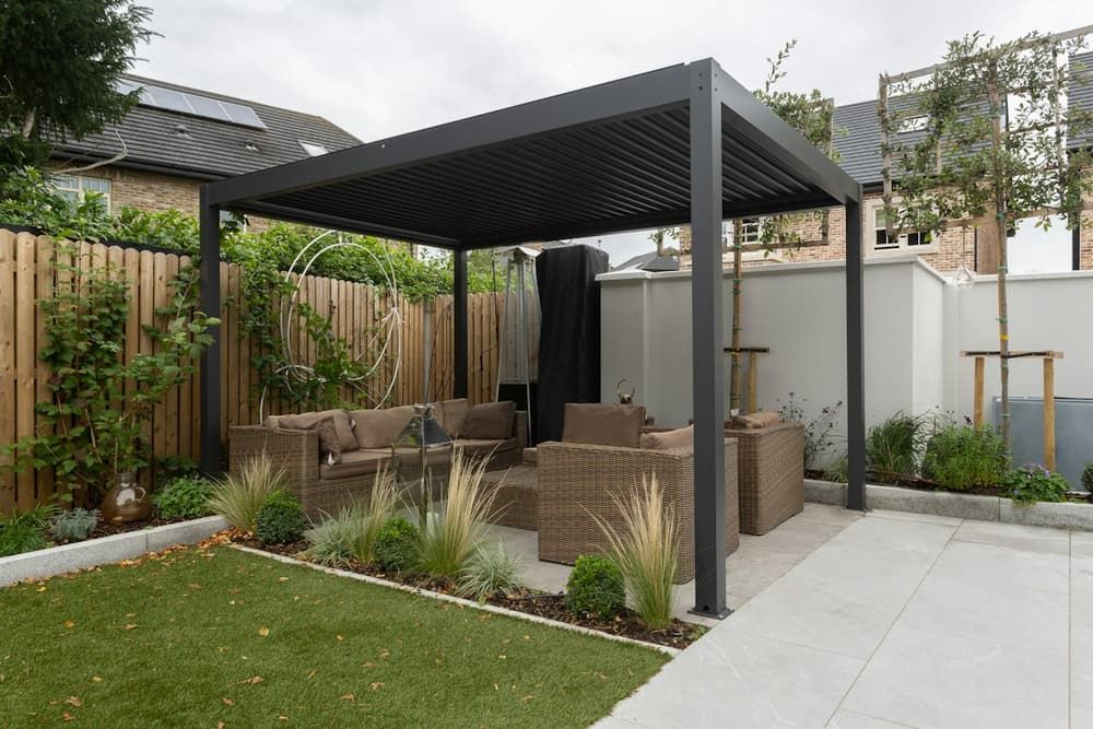 Pergola autoportante noire au-dessus d’un salon de jardin